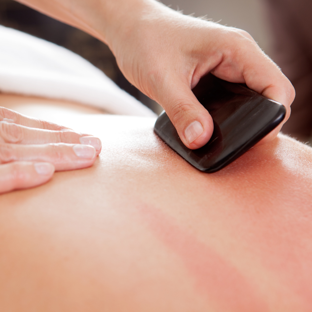 Provider giving a gua sha treatment to someone on their back