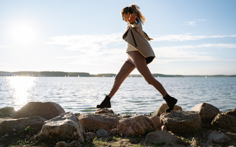 woman walking on rocks at the beach